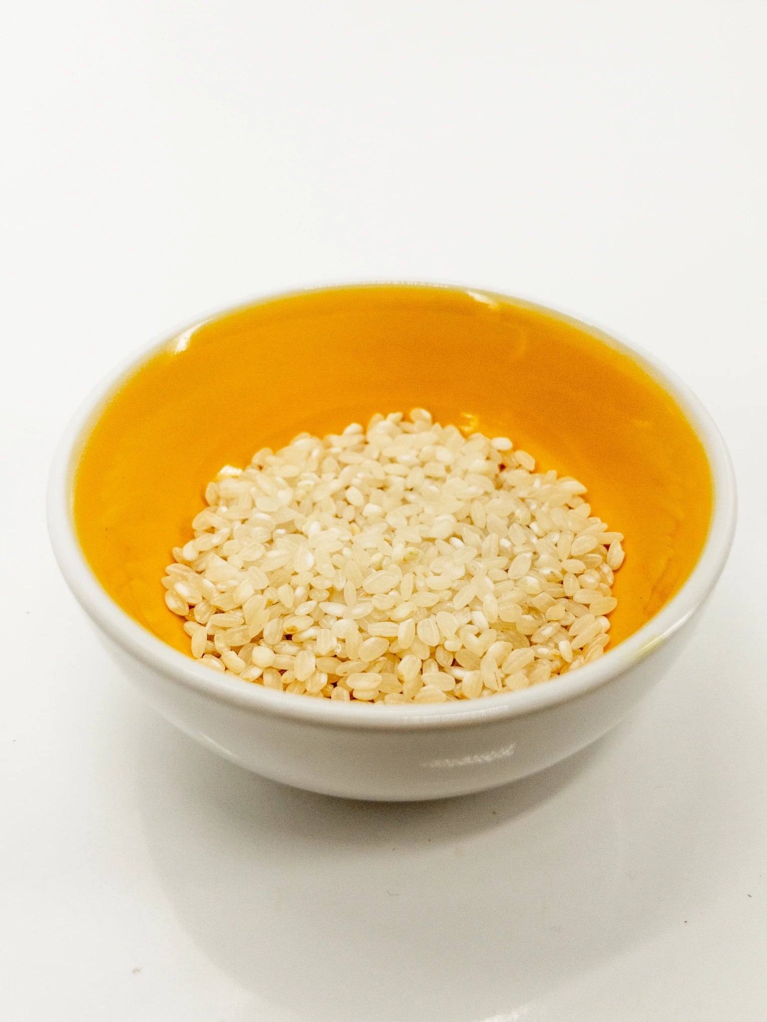 Bol de riz blanc dont l"intérieur est jaune contenant des grains de riz japonais secs | Eat in Japan épicerie en ligne